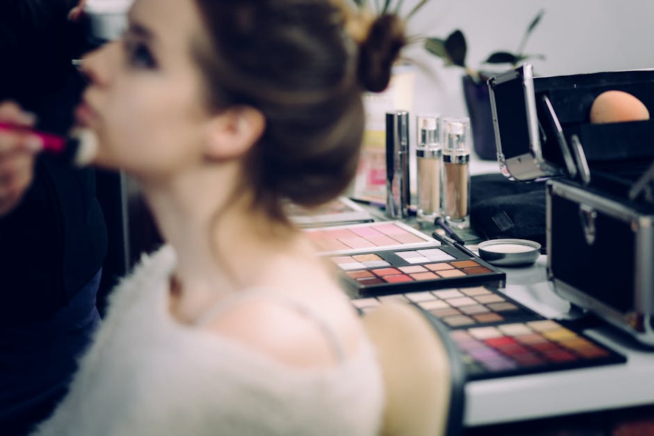 A woman receiving professional makeup in a studio with various cosmetics in focus