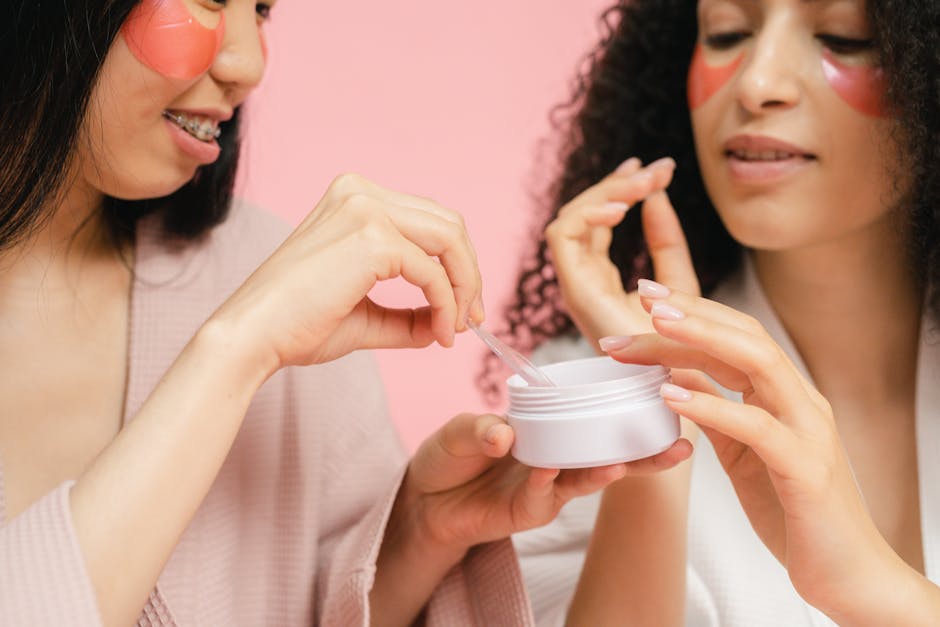 Two women in bathrobes applying skincare products with pink eye masks. Perfect for wellness and beauty themes