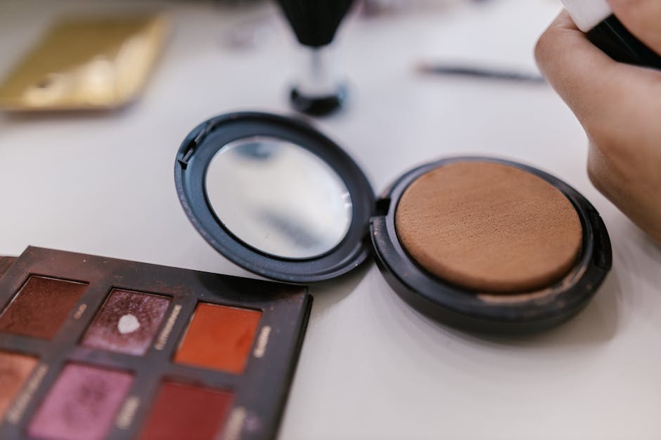 Detailed shot of makeup palette and compact powder on a table, perfect for beauty related content