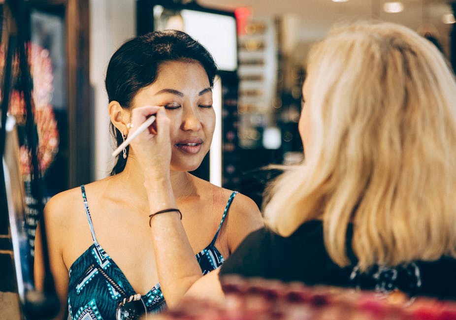 A makeup artist expertly applying cosmetics to a woman in a stylish New York City salon