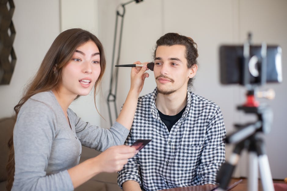 Woman applying makeup to a man during a tutorial session indoors