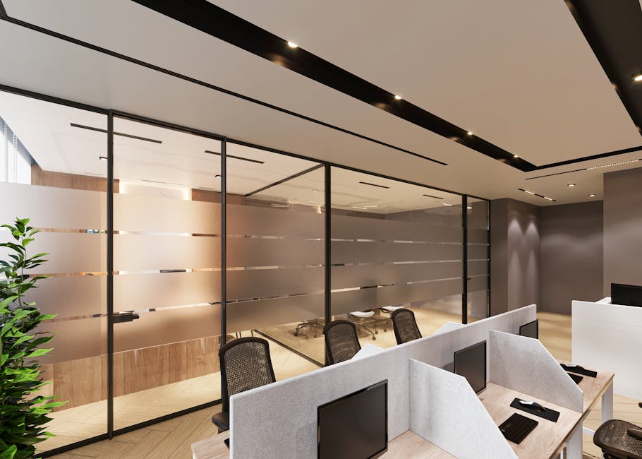 Contemporary office space featuring sleek cubicles and large glass partitions.